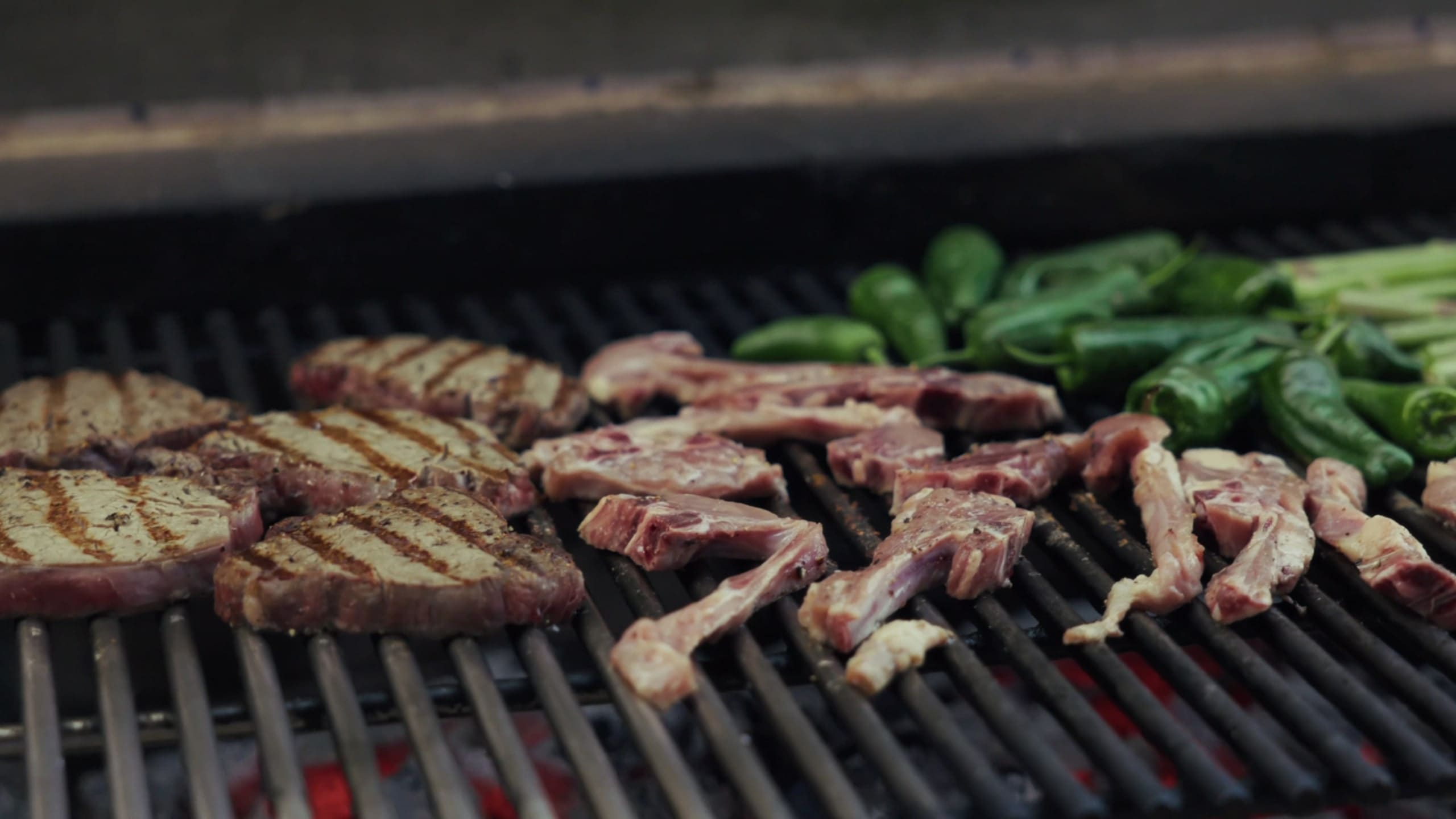 Steaks and green peppers on the barbecue.