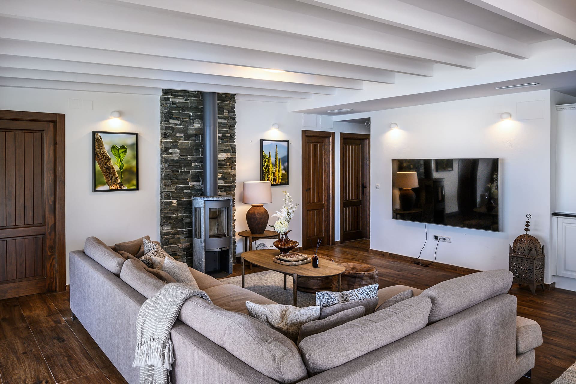 The living room at El Cortijo, a large corner sofa facing a wood-burning stove.