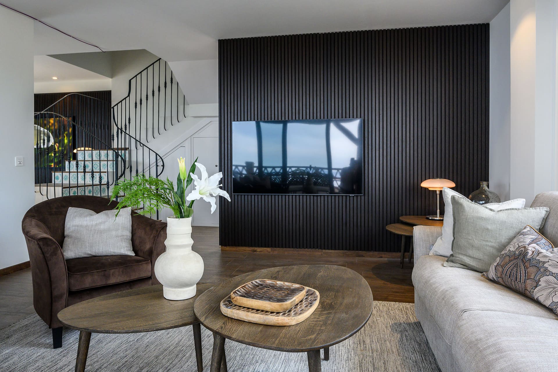 The living room at Villa Limón, sofas around low wooden tables and a staircase behind.