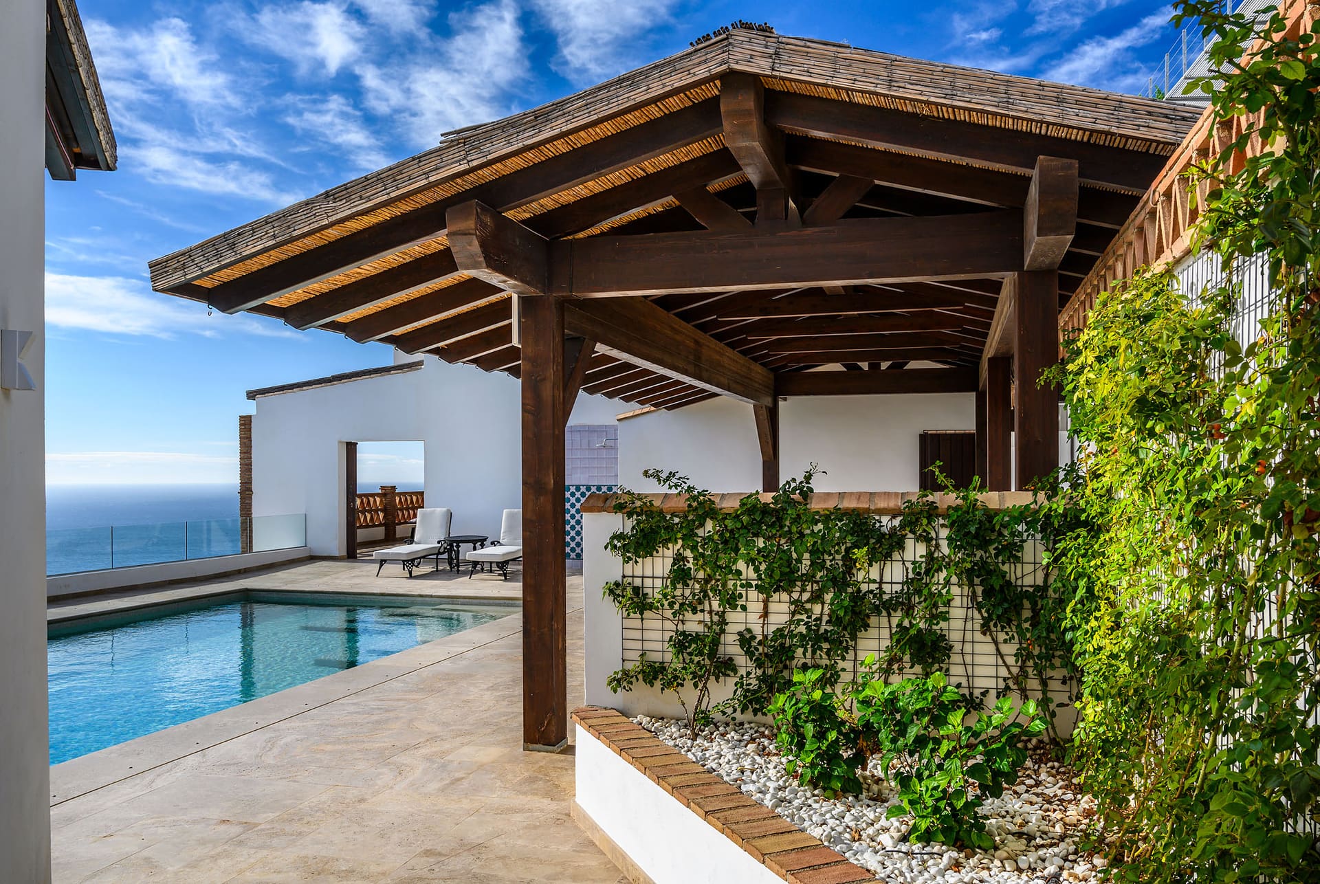 The pergola beside Villa Limón's pool, climbing plants and the sea beyond.