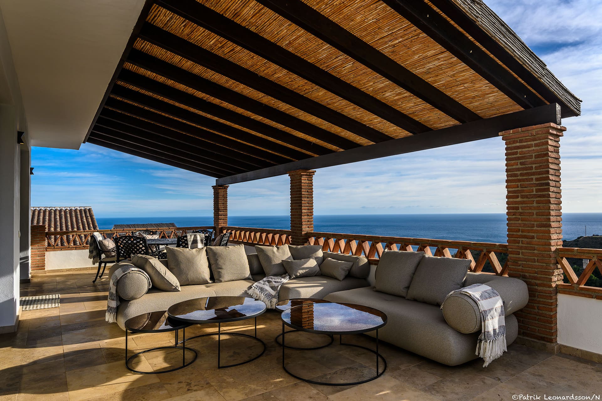 The covered terrace at Villa Mango, sofas facing the Mediterranean.