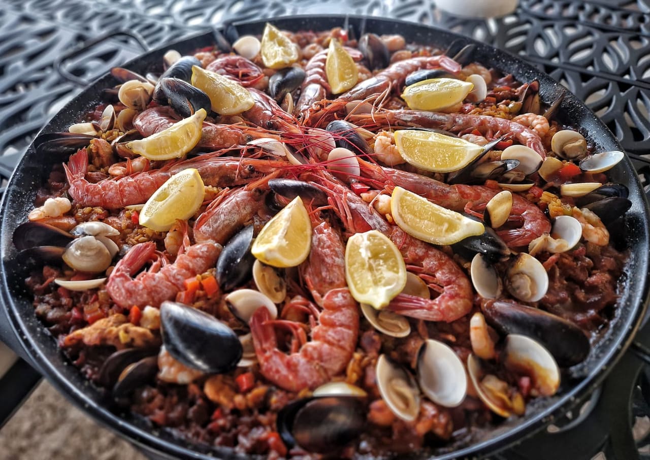 Eine Meeresfrüchte-Paella mit Garnelen, Muscheln und Zitrone.