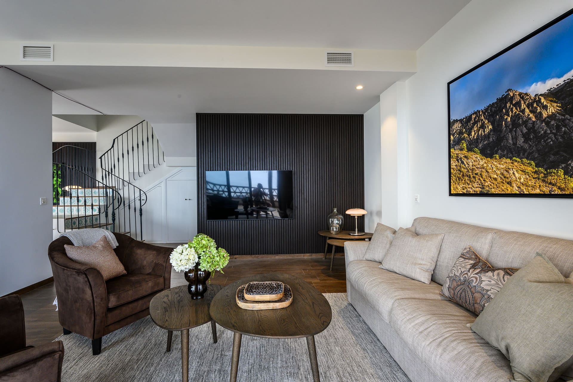 The living room seen from the front, sofas facing the glass doors.