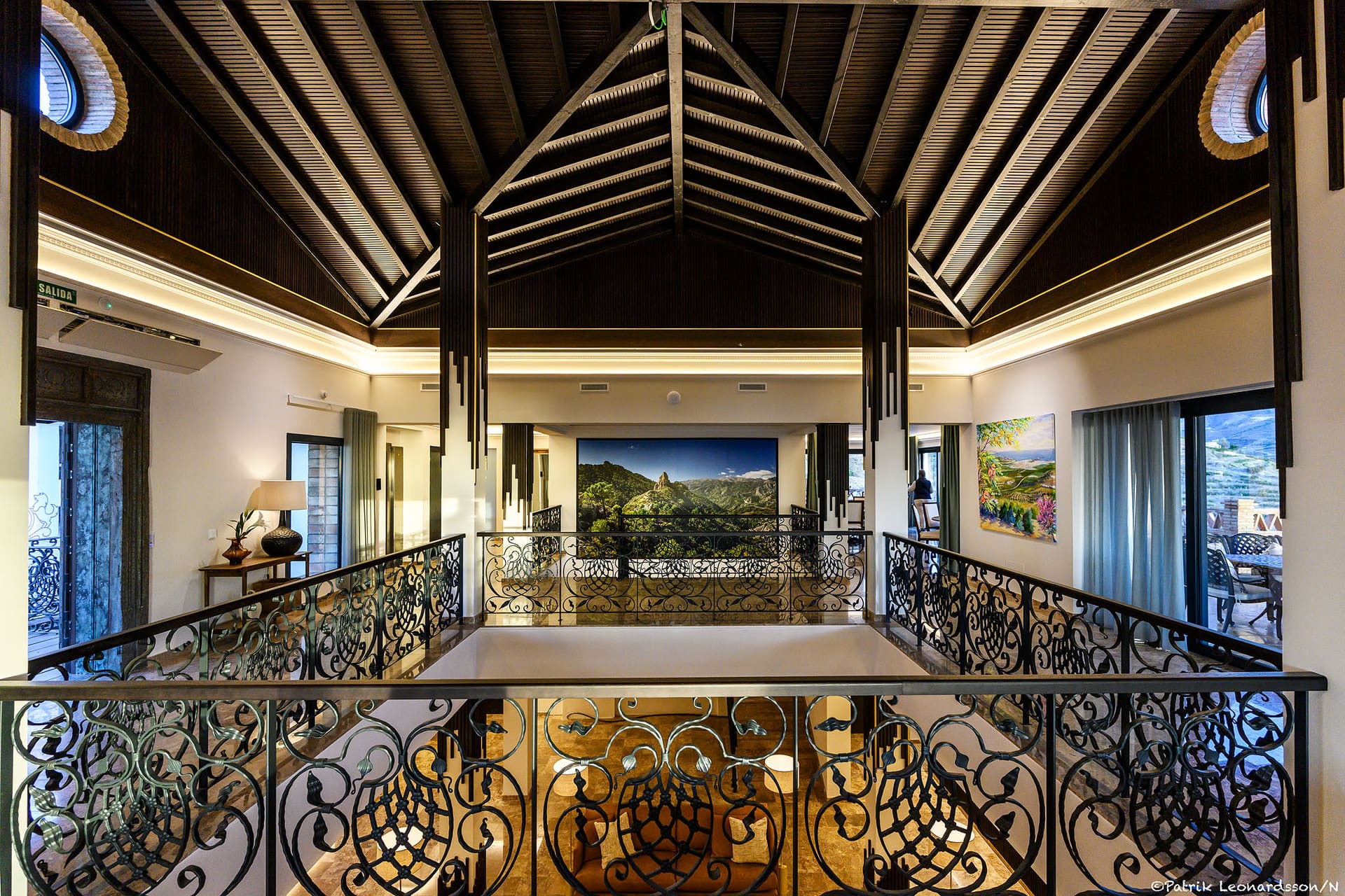 The atrium at El Palacio, a high timber ceiling above a wrought-iron gallery.