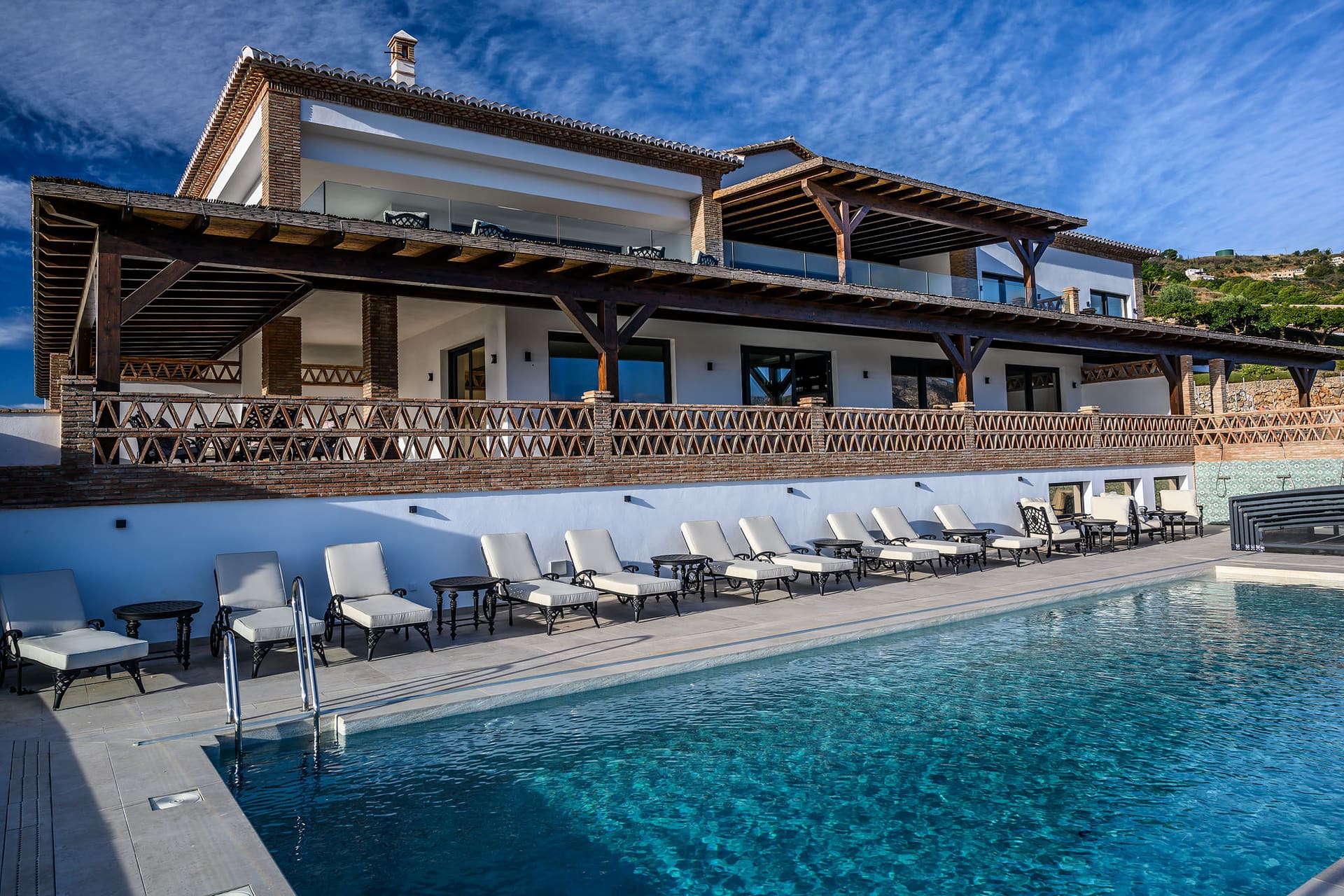 El Palacio's pool and loungers, the white facade and its long terrace above.
