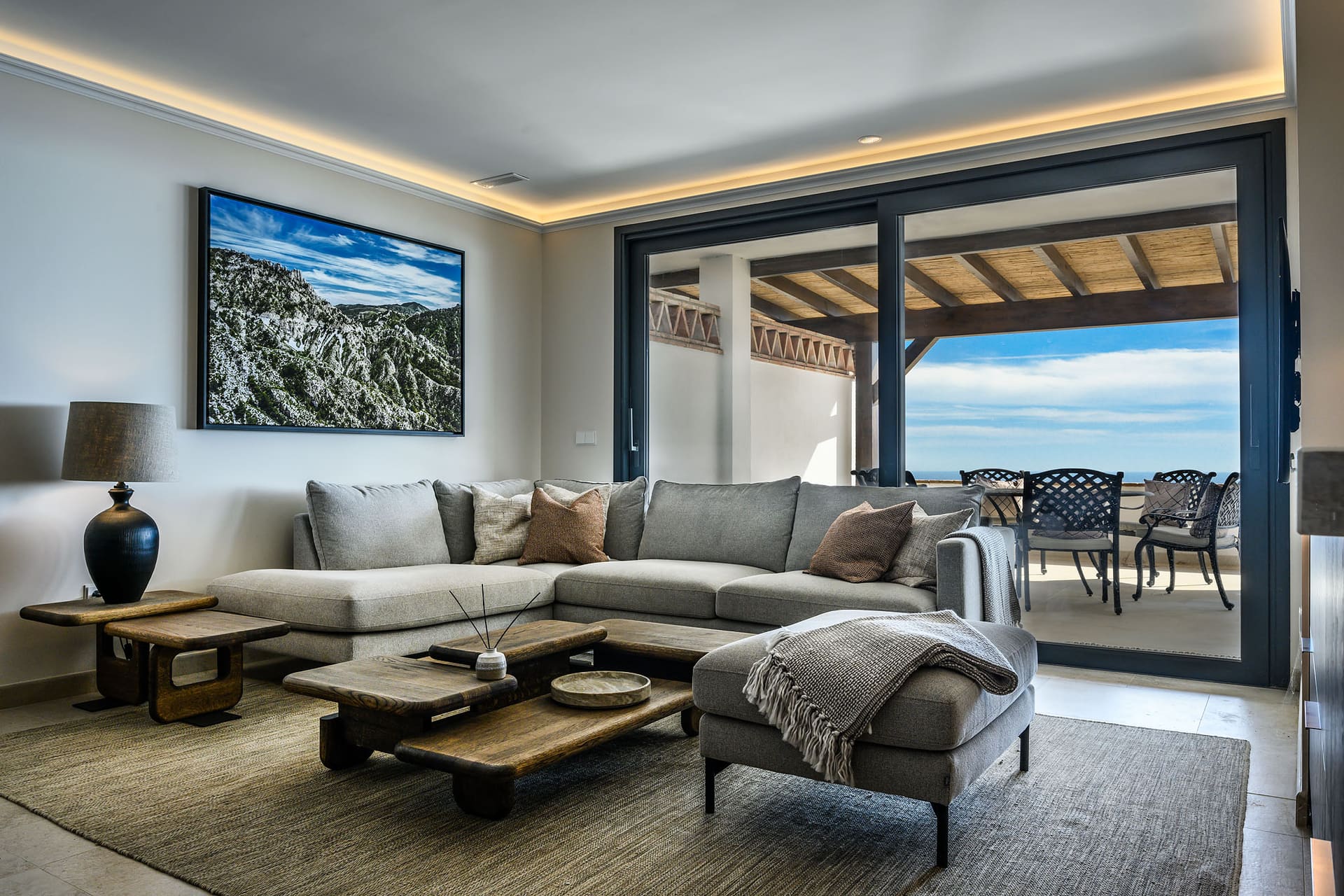 A suite's living room at El Palacio, glass doors open onto the terrace and the sea.