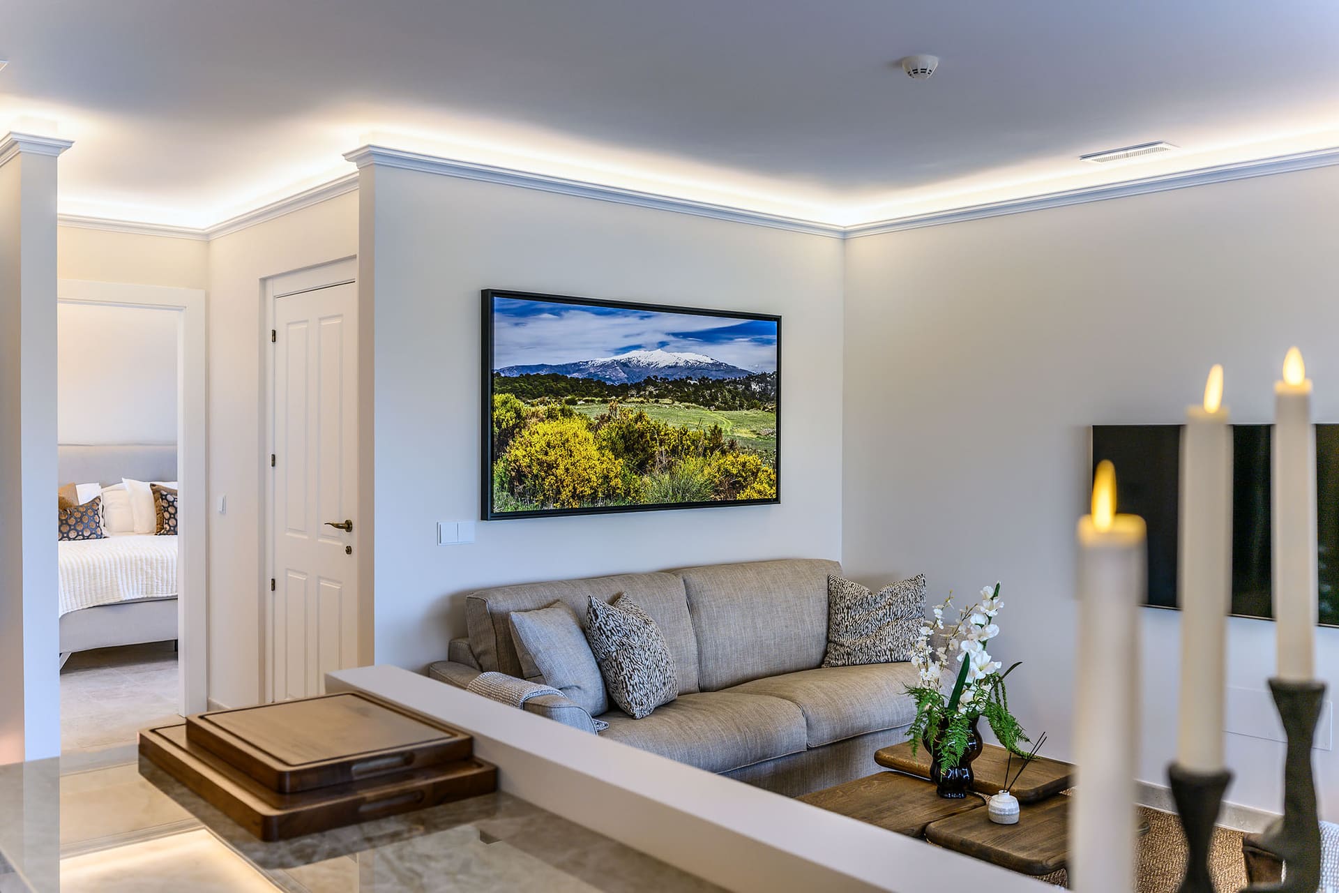 A sunken sitting area in a suite, candles lit and the bedroom beyond.