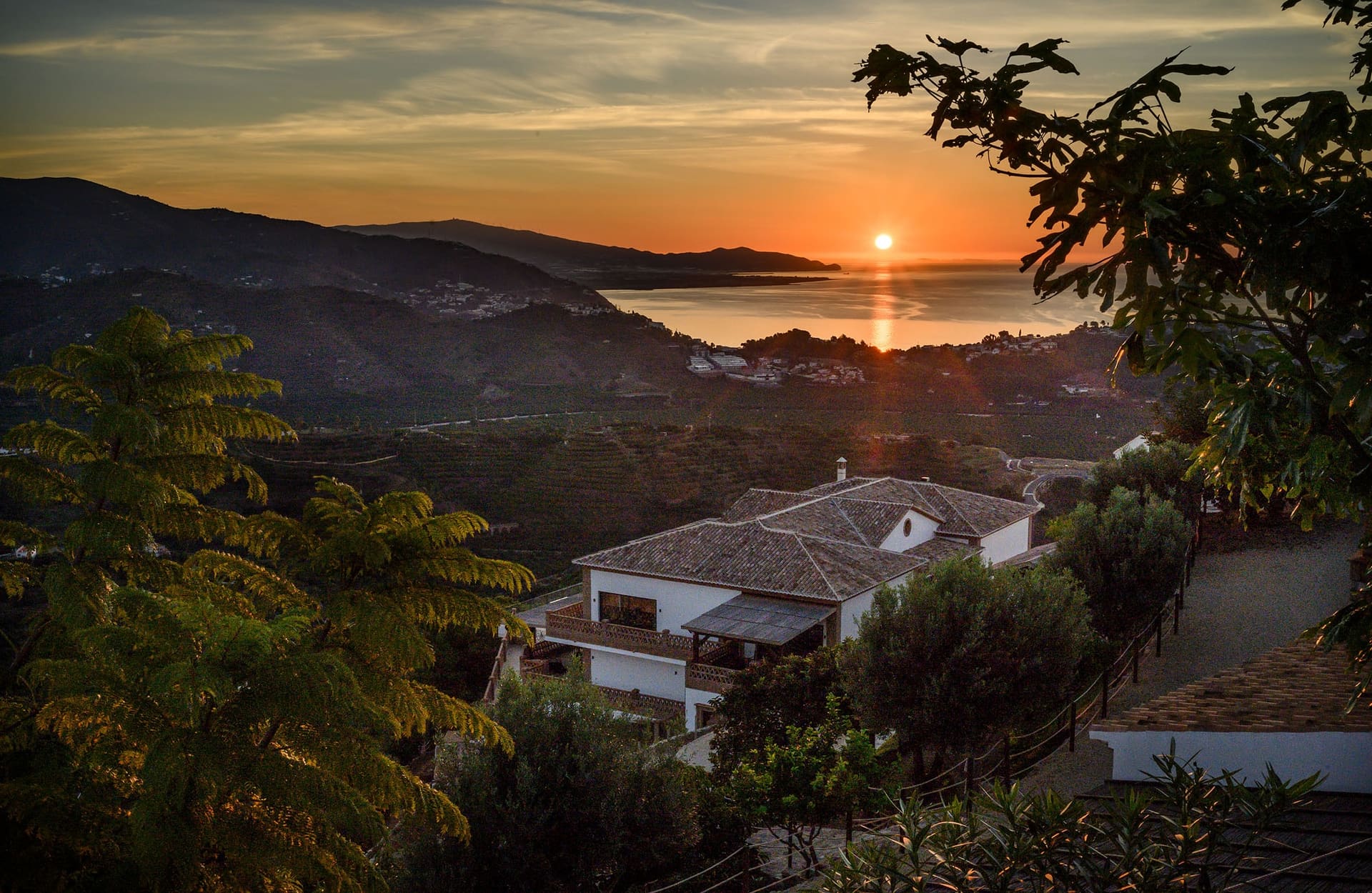 Sunrise over the coast, the hills and the white villas still in shadow.